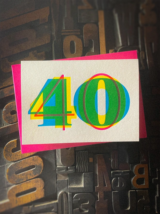 Contemporary handmade letterpress 40th birthday card featuring a bold oversized "50" in a vibrant typographic design. Printed using overlapping cyan, magenta and yellow inks to create striking secondary colours with a deep tactile letterpress impression. Individually hand printed on premium 350gsm GF Smith Colorplan card and paired with a high-quality 135gsm GF Smith Colorplan envelope in a complementary colour. Produced on a beautifully restored 1915 Arab Crown Folio press.