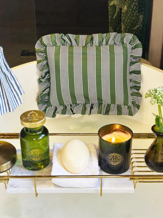 luxury frilled bath pillow. a grey and green striped frilled bath pillow affixed to a bath with candles.