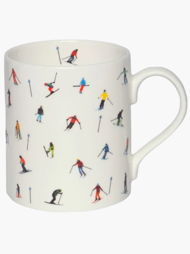 Ski Slope Mug. A white mug patterned with a simple multicoloured skier design, set against a mountain scene.