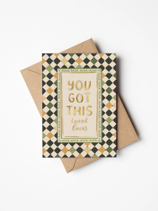 You got this (good luck) text in gold foil with checkerboard background