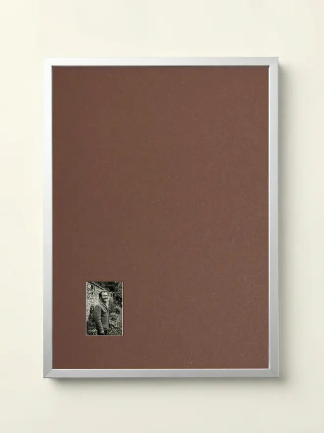 Brown Mounted Silver Picture Frame, hanging on a white wall.