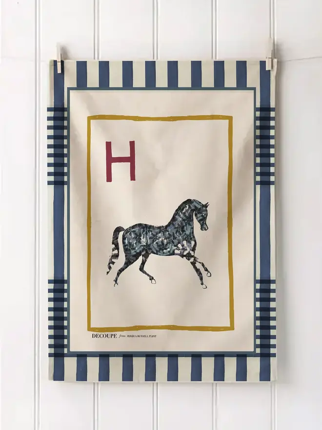 a-z alphabet tea towel. a tea towel with a horse print and the letter 'h' in the corner.