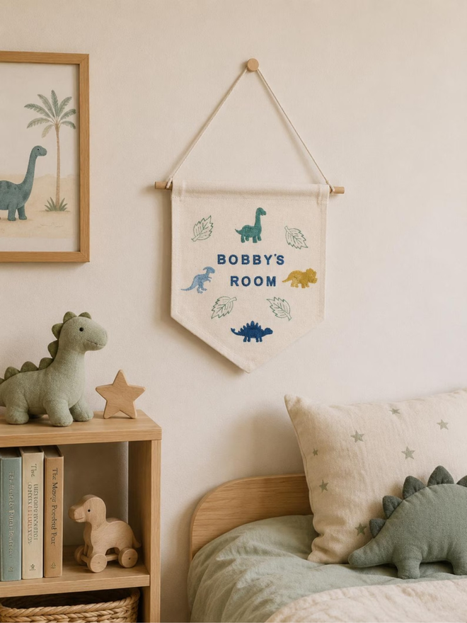 customised kids' bedroom cotton wall hanging. a banner with printed animals hanging on a bedroom wall.