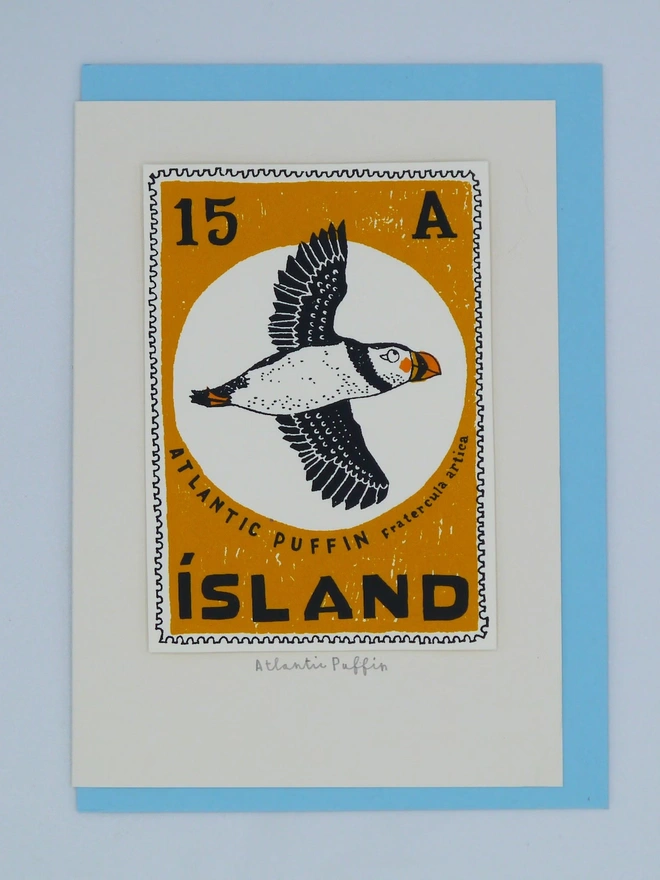 Bird Stamp Card Atlantic Puffin/ Iceland, a white card with a colourful bird design in the centre against a blue envelope on a white background. 