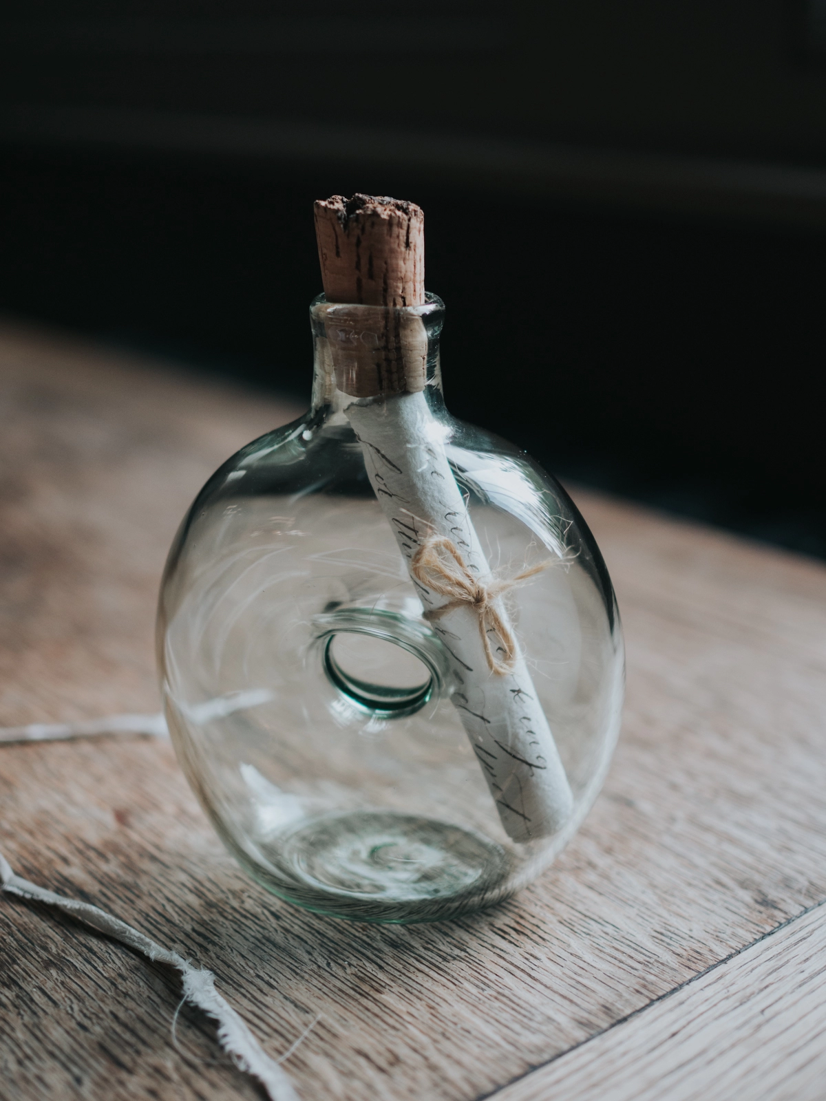 Message in a bottle, on a table next to a ribbon