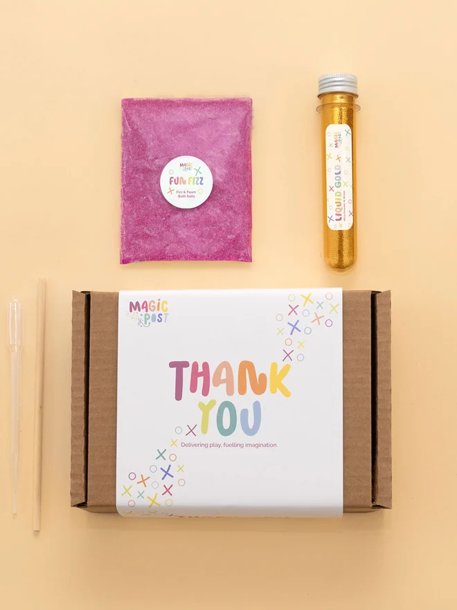 sensory party potion box. tube of gold glitter and pink bath salts photographed with packaging box.