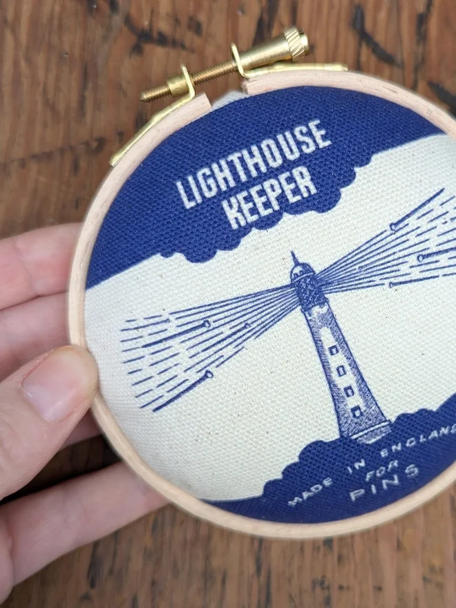 Hand holding royal blue Lighthouse keeper pin cushion