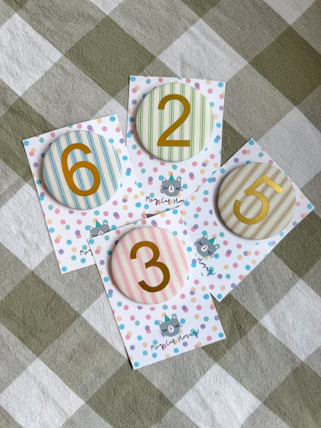 Ticking Stripe number birthday badges in pink, blue, beige and green