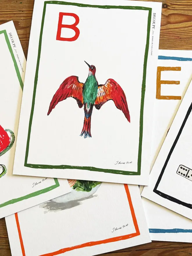 signed a-z alphabet prints. illustrated art prints bearing alphabet letters in a pile.