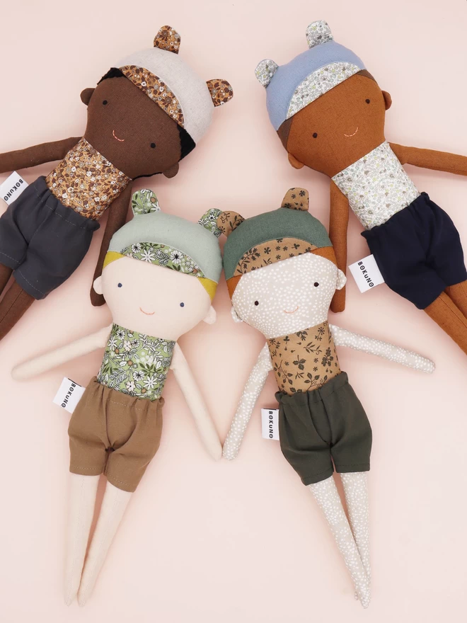 fabric boy dolls with floral tops in dark and light skin tones 