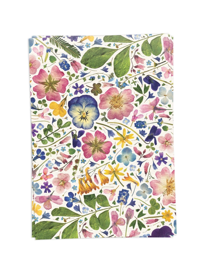 2 Folded wrapping paper sheets with a floral design created from pressed flowers.
