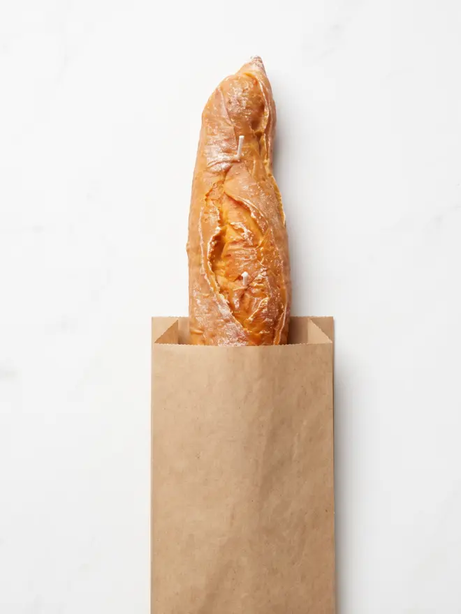 baguette candle in brown paper bag