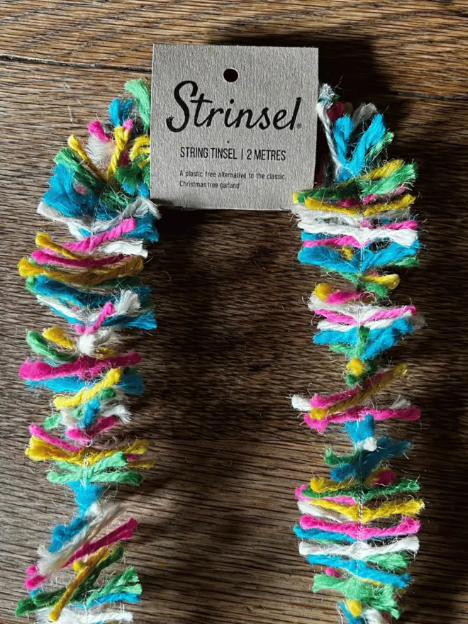 Neon Pop Strinsel with label AKA Jute string tinsel on an oak table