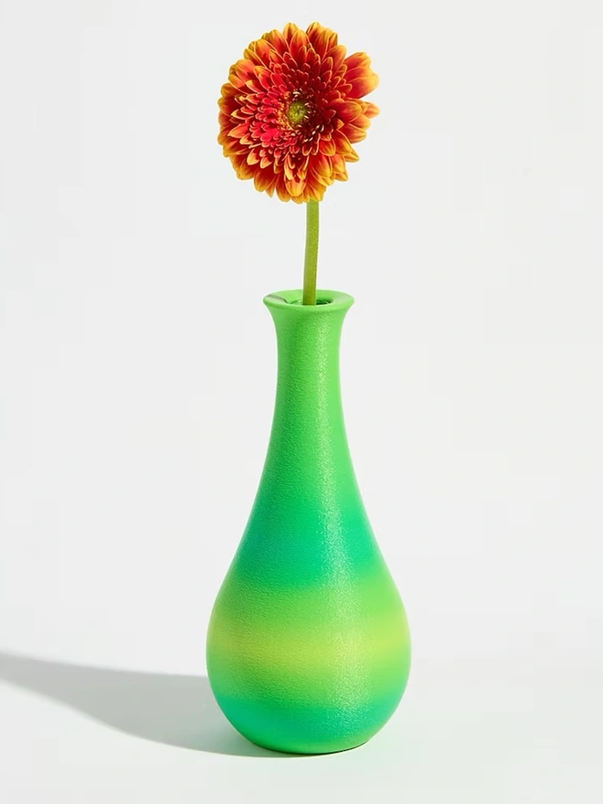 3d printed vase in green stripes with bright pink flower