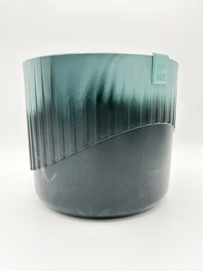 Ocean Plastic Plant Pot Medium, a recycled blue plant pot sitting on a plain surface against a white backdrop. 