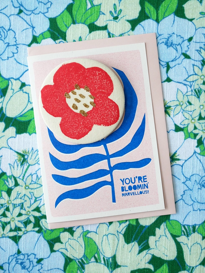 Flower card with badge sat in vintage fabric