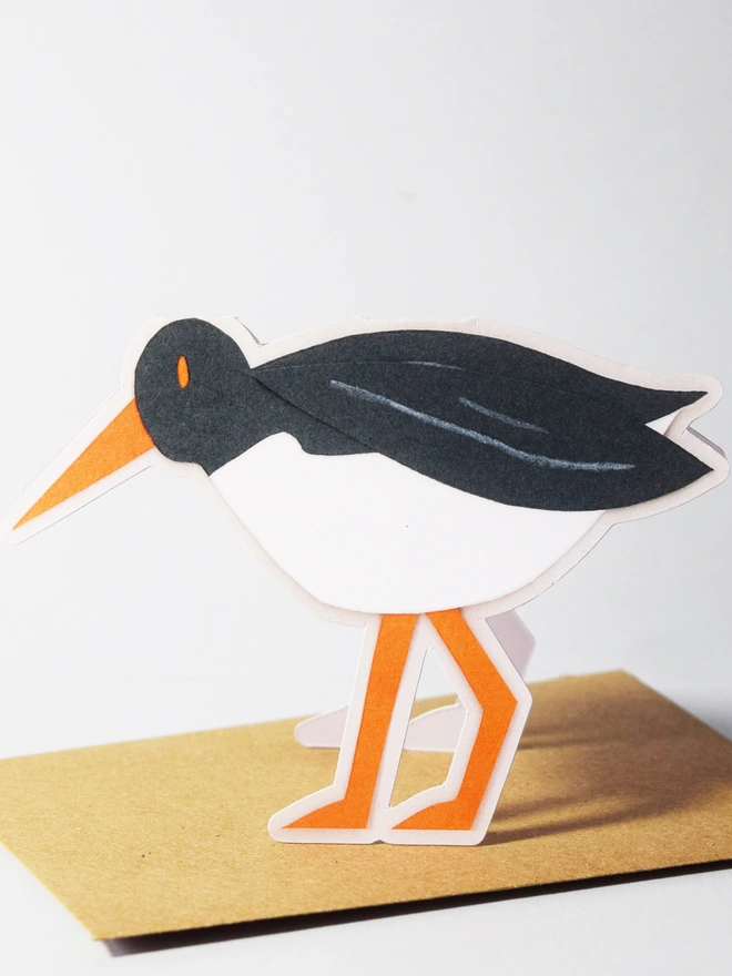 A cut out card of an oystercatcher sitting on top of an envelope