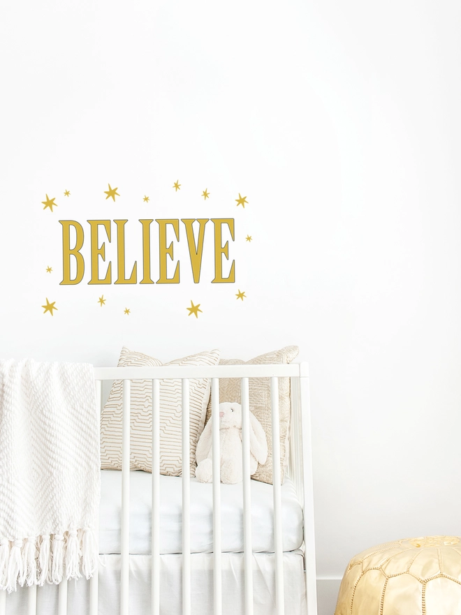 believe wall sticker with gold stars surround wording above a cot