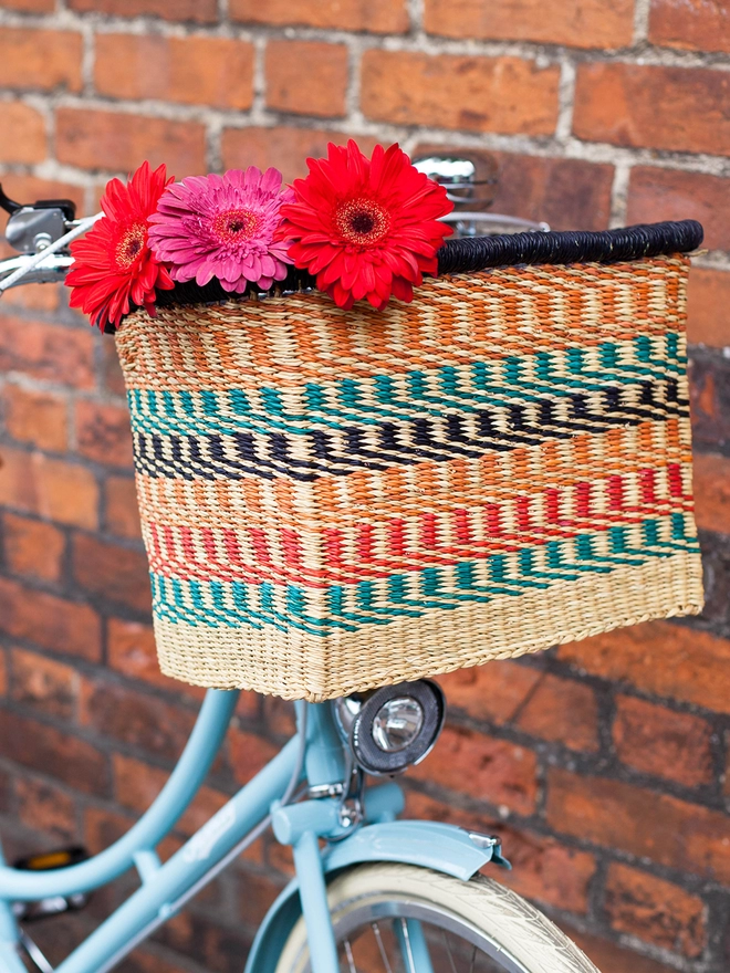 blue bike with colourful bike basket styled with bright flowers