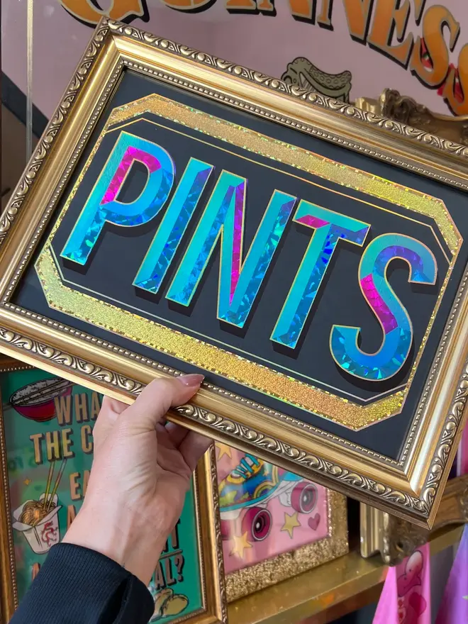'Pints' ScreenPrint, a colourful screenprint that says 'Pints' held by a person, it sits on a black blackdrop