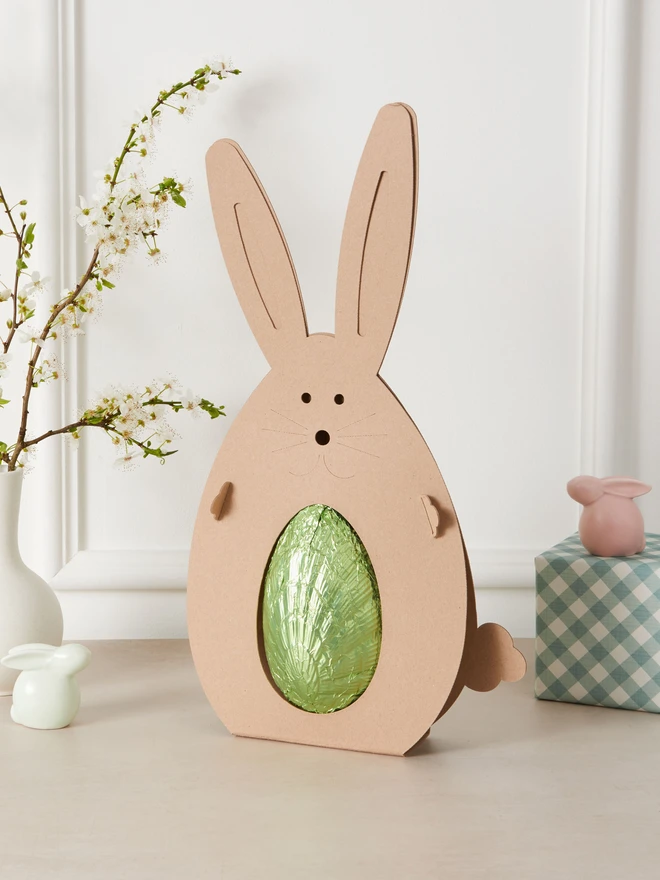 ginger dark chocolate easter egg 72%. a dark chocolate easter egg photographed in green foil in a cardboard rabbit.