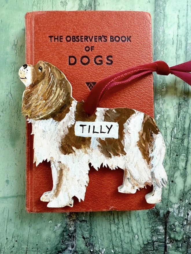 King Charles Spaniel Christmas decoration placed on a red book