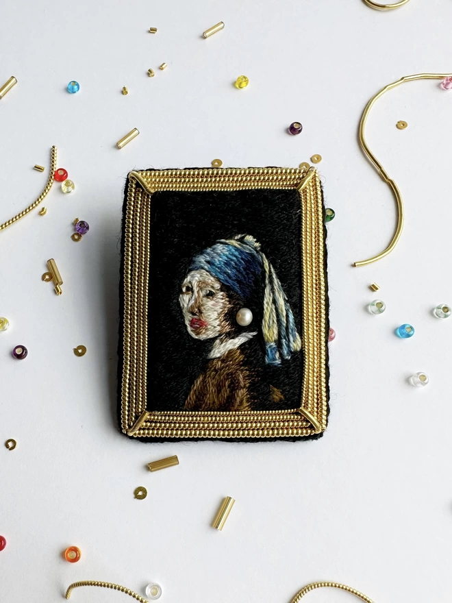 Pearly girl brooch on background with beads