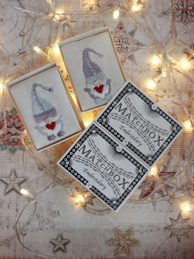 Showing 2 colour variations of the embroidered Gonk, displayed in their matchboxes. With fairy lights.