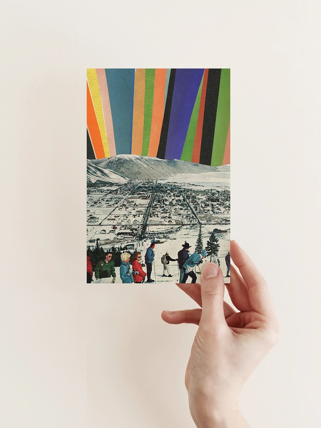 A Christmas card featuring a group of skiers enjoying the view of the northern lights.
