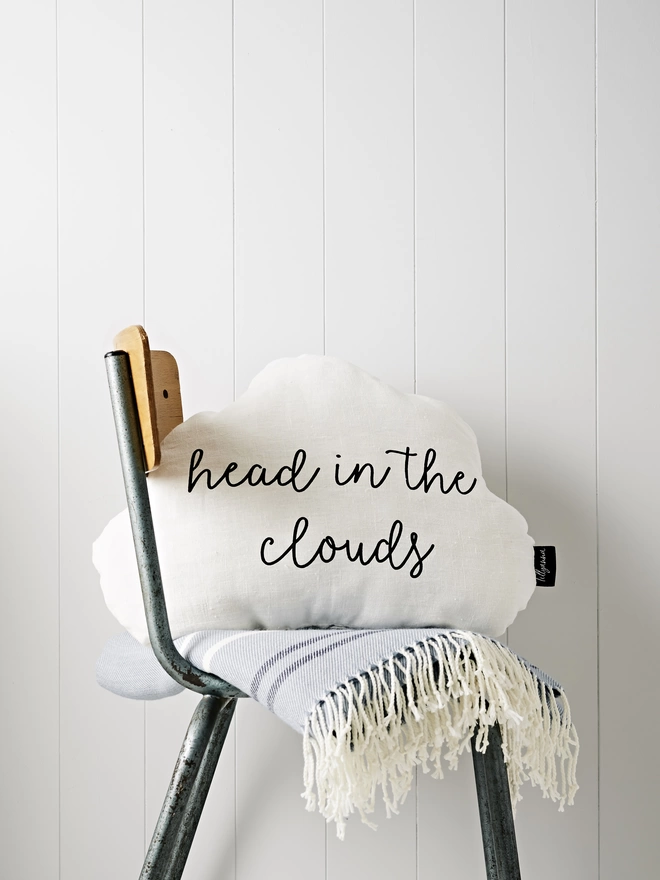 Cloud shaped cushion with the words 'head in the clouds' printed