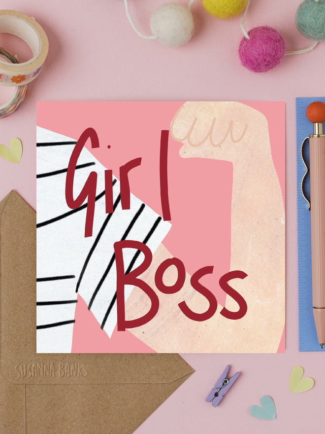 'girl boss' illustrated card. card photographed on table with assorted crafting items.