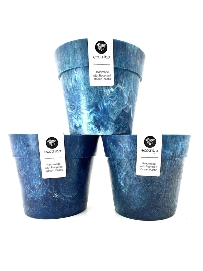 Small Blue Ocean Plastic Plant Pot, a collection of blue recycled pots sitting on a white surface against a plain backdrop. 