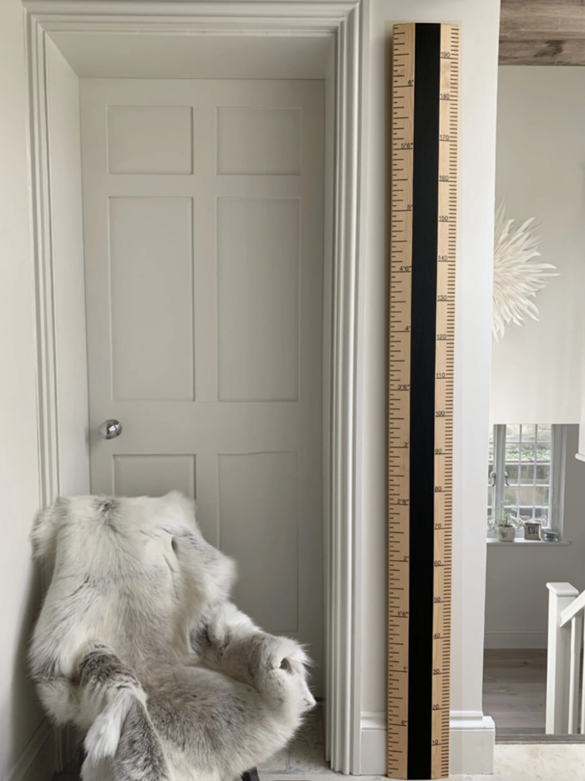 Blackboard Ruler Height Chart. A wooden and black ruler leaning against a child’s wall.