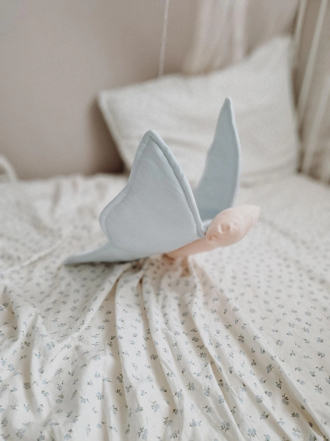 Butterfly Nursery Decoration, a colourful butterfly decoration sitting on a child's bed. 