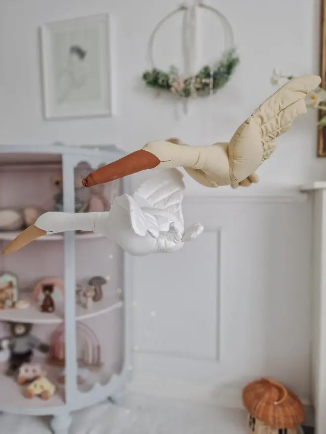 Flying Swan Hanging Decoration, a hanging beige swan decoration, suspended in a child's bedroom. 