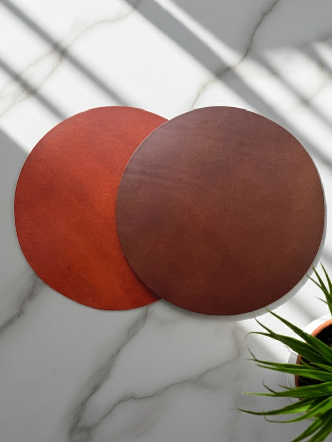 The two different colour options, brown and tan leather mouse pads.