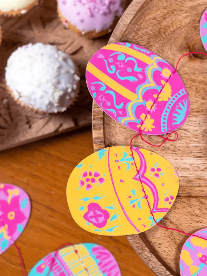 Colourful yellow and pink egg decorations on wooden table 