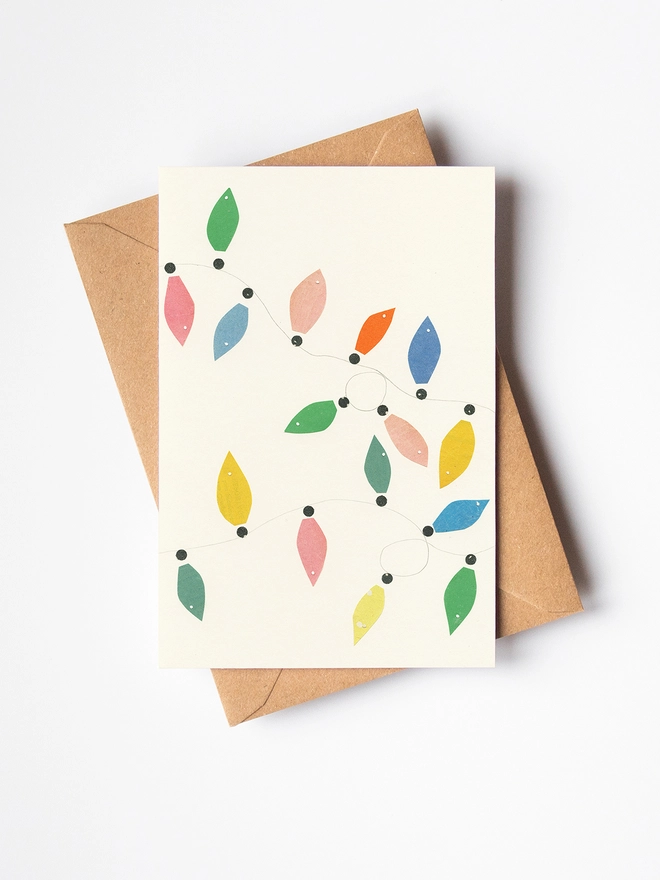 A minimal Christmas card featuring of pastel coloured fairy lights.