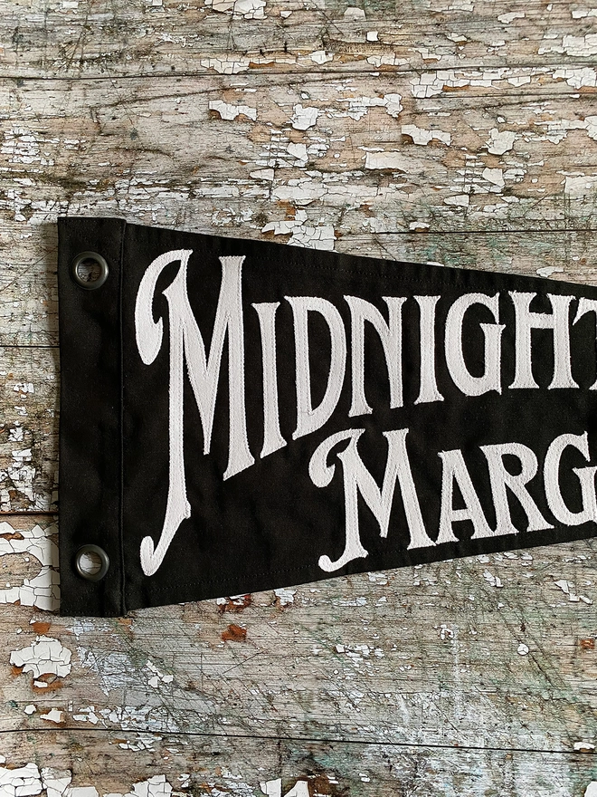 Black flag white writting Midnight Margarita Club Practical Magic