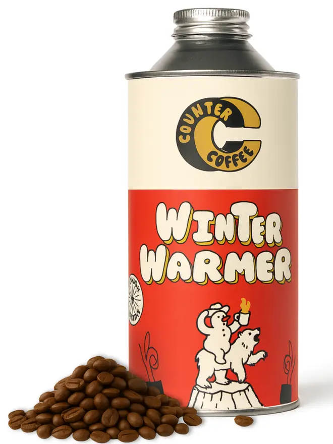 Winter Coffee with coffee beans next to it placed infront of a white background
