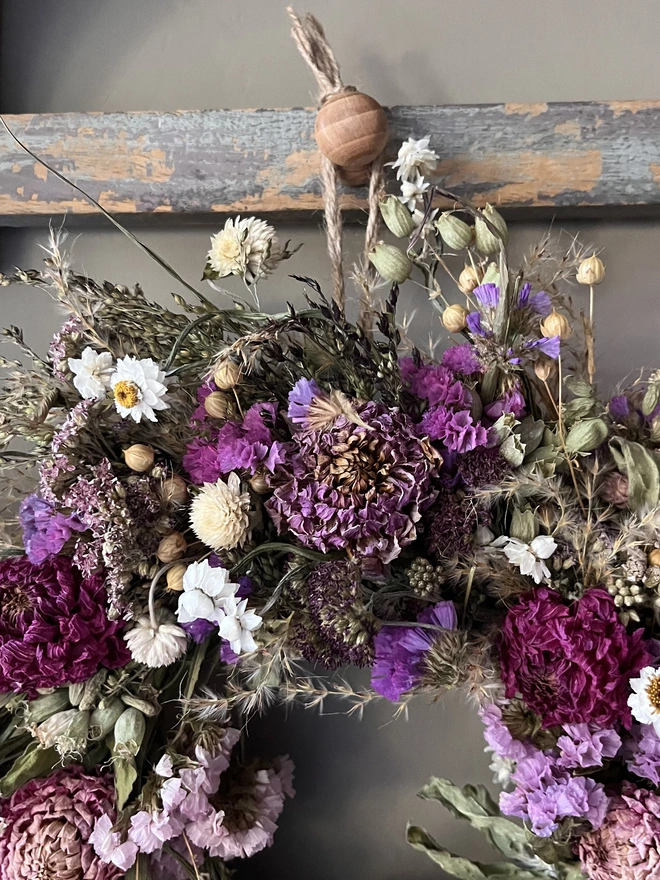 Pink and purple flower wreath made with a selection of seasonal blooms and dried dahlias. 
