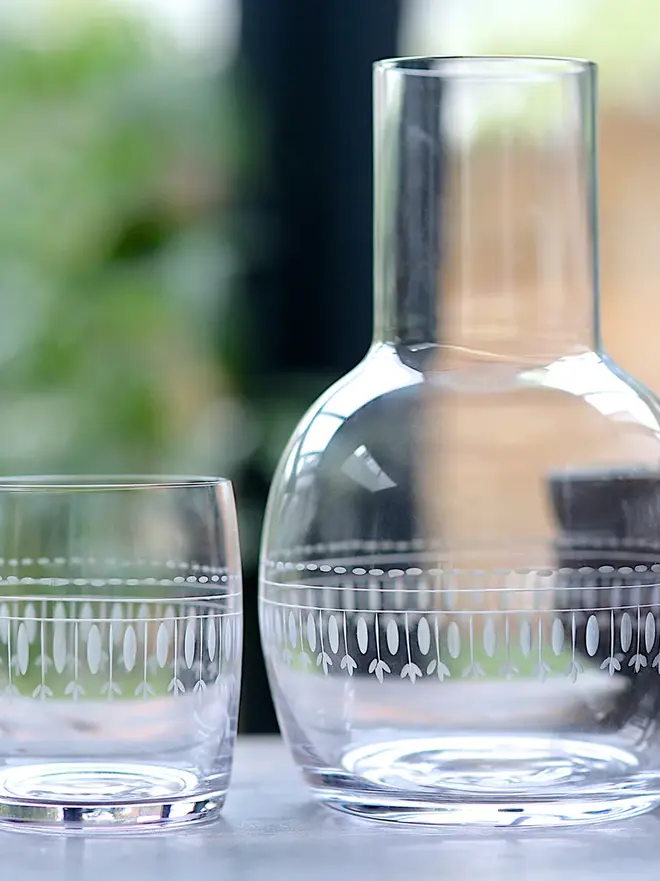 engraved ovals crystal carafe set. a glass carafe and matching glass with a delicate oval pattern.