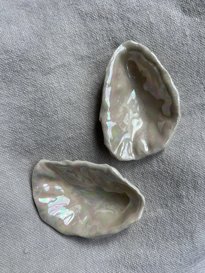 a set of two handmade porcelain oyster shells made of porcelain and hand formed from a real oyster shell.