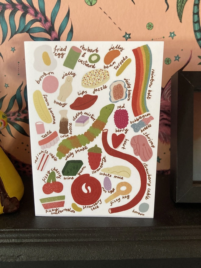 Greetings card with illustrations of pick n mix sweets, on a fireplace