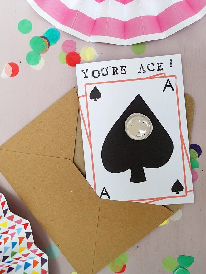 ace of spades greeting card with happy face pin badge