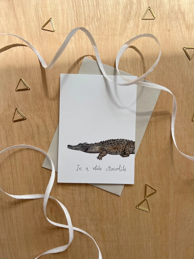 greetings card featuring an illustrated crocodile and the phrase “in a while crocodile”