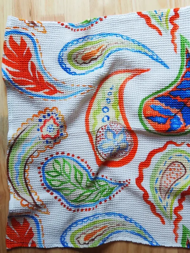 Paisley Waffle Tea towel, laying on a wooden table. 