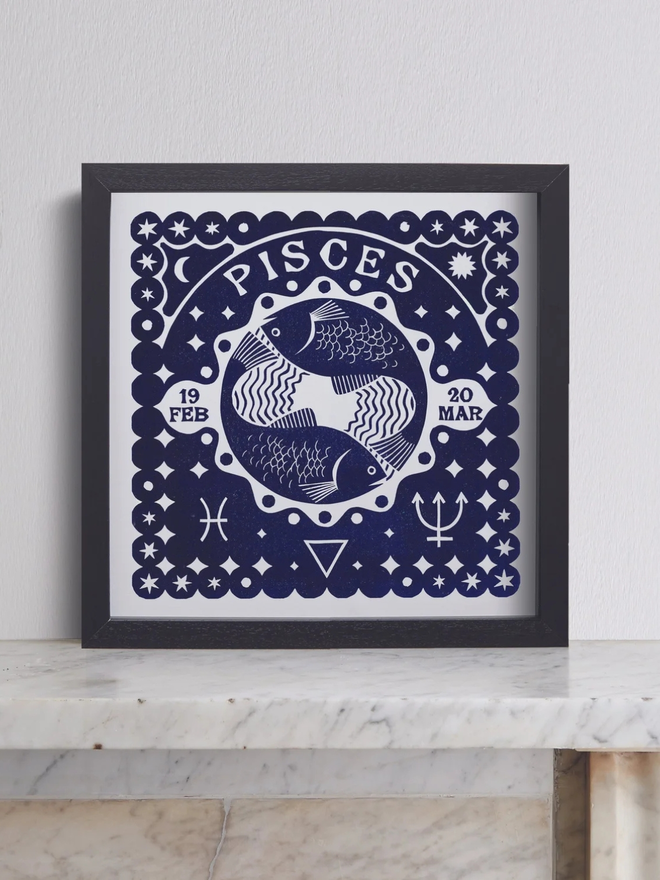 pisces zodiac linocut. linocut fish and zodiac symbols printed on a blue background.