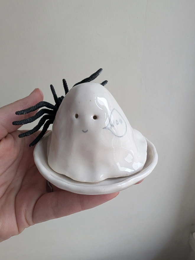 white ceramic tealight in the shape of a Halloween ghost with the word boo and a scary spider