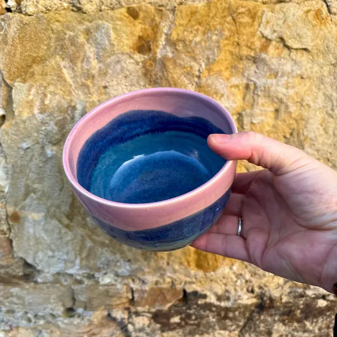 Landscape Small Bowl, a colourful bowl held against a brick backdrop. 